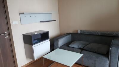 Modern living room with grey sofa and glass coffee table