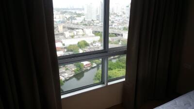 Bedroom with large window view of cityscape