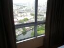 Bedroom with large window view of cityscape