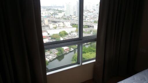 Bedroom with large window view of cityscape