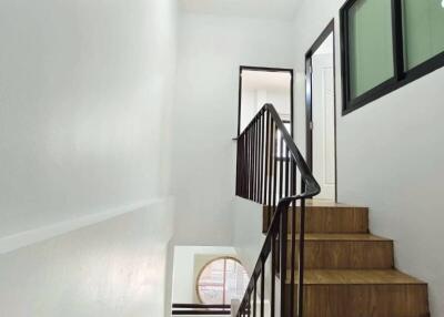Modern staircase with wooden steps and black railings