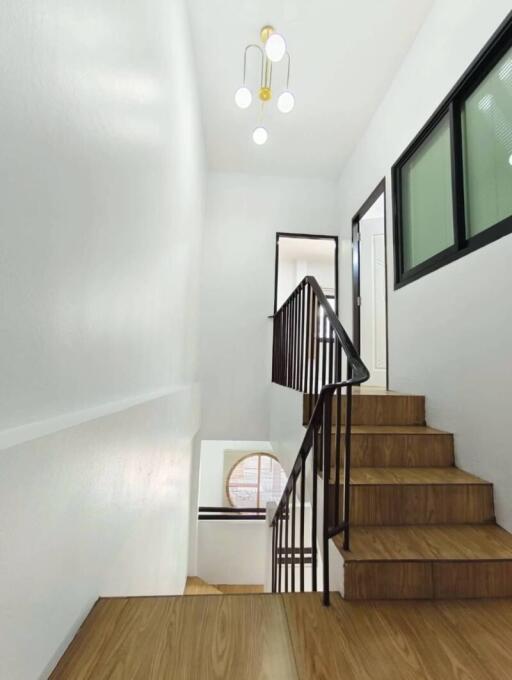 Modern staircase with wooden steps and black railings