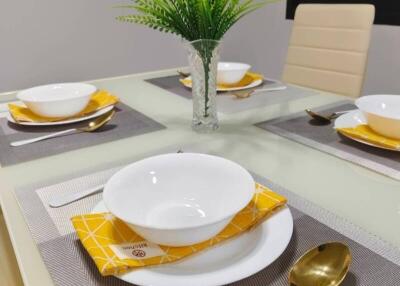 Modern dining table setup with white dishes and gold flatware