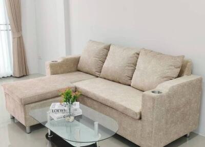 Spacious living room with a beige sofa and glass coffee table