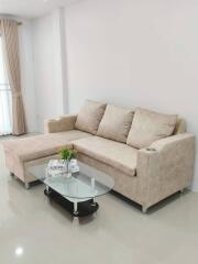 Spacious living room with a beige sofa and glass coffee table