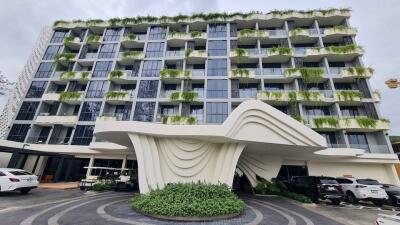 Modern building with unique architecture, multiple balconies, and greenery