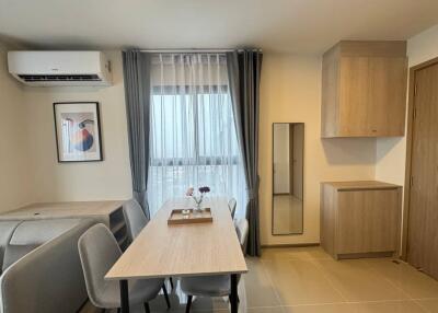 Modern dining area with table, chairs, air conditioner, and decorative elements