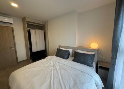 Bedroom with modern decor including a double bed, bedside lamp, and air conditioning