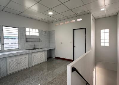 Kitchen area with staircase and large windows