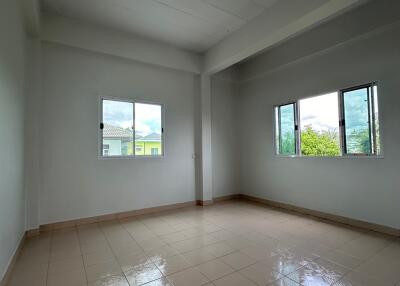 Empty bedroom with tiled floor and windows