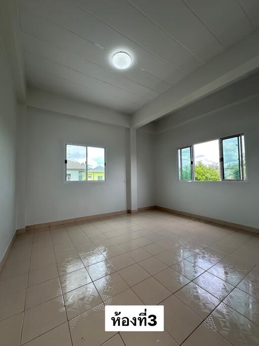 Empty bedroom with tiled floor and windows