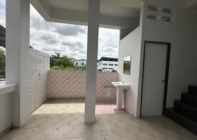 balcony with a small sink and partial tile wall