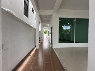 Spacious hallway connecting rooms with wooden floor tiles