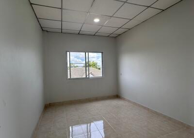 Empty bedroom with tiled floor, white walls, and ceiling lights