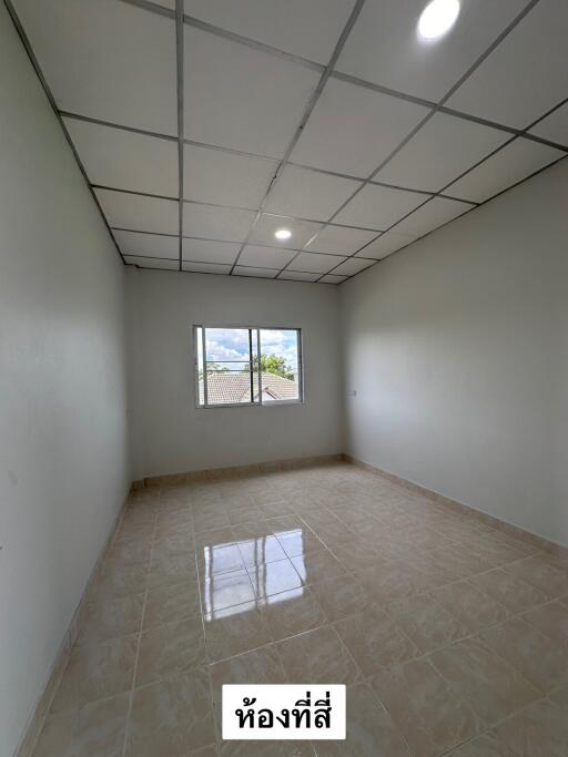 Empty bedroom with tiled floor, white walls, and ceiling lights