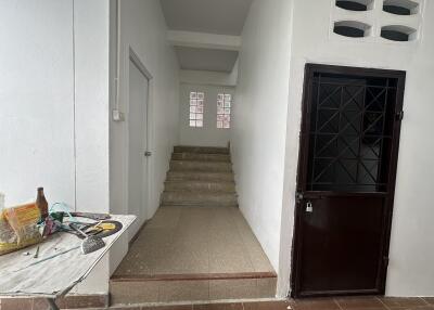 Staircase in building with a black door and tiled floor