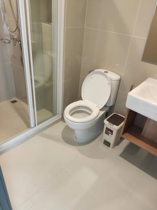 A modern bathroom with a shower, toilet, and sink