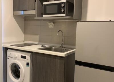 Compact kitchen with sink, microwave, and washing machine