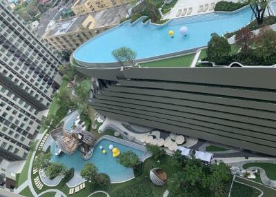 Overhead view of a modern apartment building with swimming pools and landscaped gardens