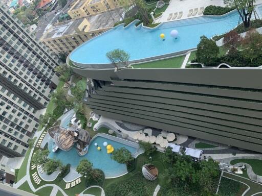 Overhead view of a modern apartment building with swimming pools and landscaped gardens