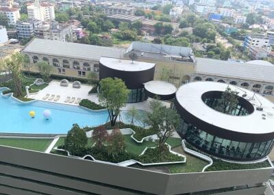 Aerial view of a modern building with a pool and green landscaping