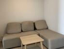 cozy living room with a gray sectional sofa and a small wooden coffee table