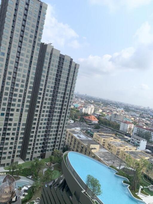 High-rise apartment building with a view of a swimming pool and cityscape