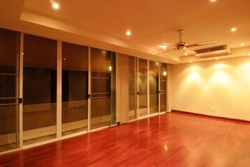 Spacious living room with hardwood floors, ceiling fan, and large sliding glass doors