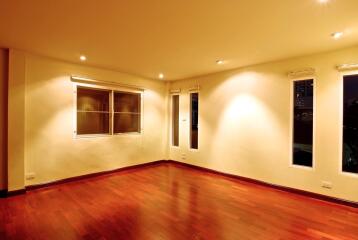 Spacious empty living room with wooden floor and large windows