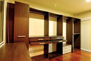 Spacious bedroom closet with wood shelving and drawers