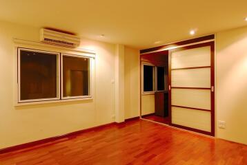 Living room with hardwood flooring and windowed wall