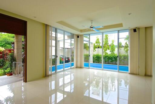 Spacious living room with large windows and pool view