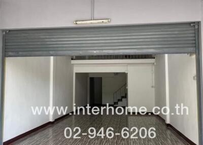 Spacious indoor garage with roller door and stairway to upper level