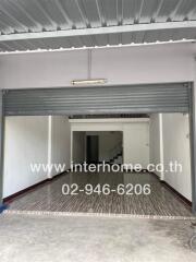 Spacious indoor garage with roller door and stairway to upper level