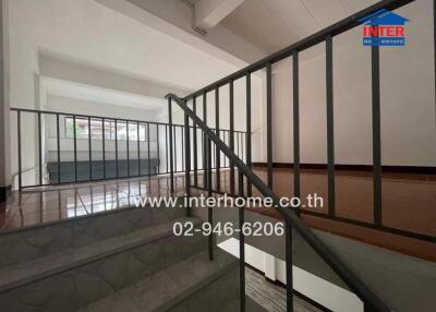 Staircase area with metal railings and polished floor