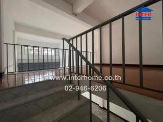 Staircase area with metal railings and polished floor