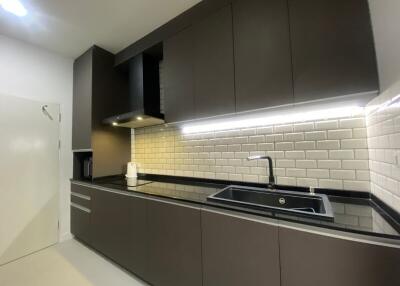 Modern kitchen with under-cabinet lighting and dark cabinetry