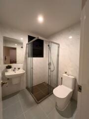 Modern bathroom with glass shower enclosure, sink, and toilet