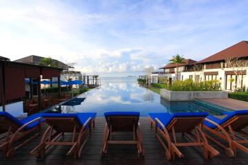 Outdoor pool area with lounge chairs and ocean view