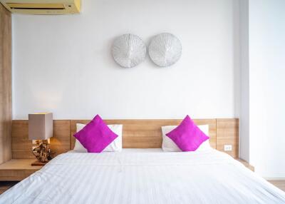 Modern bedroom with wooden elements and purple pillows