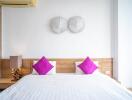 Modern bedroom with wooden elements and purple pillows