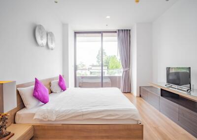 Modern bedroom with large window and wooden furniture