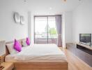 Modern bedroom with large window and wooden furniture