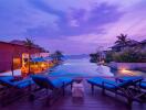 Beautiful outdoor pool area at sunset with lounge chairs and palm trees