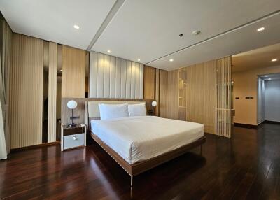 Spacious modern bedroom with wooden floors and a large bed