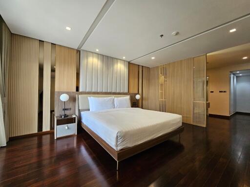 Spacious modern bedroom with wooden floors and a large bed