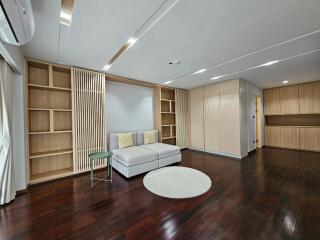 Spacious living room with built-in wooden bookshelves, sofa, and hardwood floors