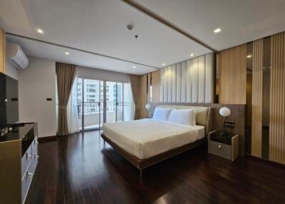 Modern bedroom with wooden flooring and a large bed