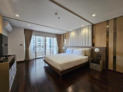 Modern bedroom with wooden flooring and a large bed