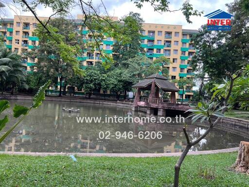 Outdoor space with pond, gazebo, and apartment building in the background